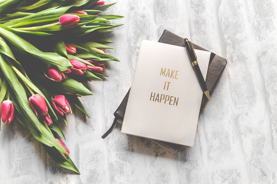 pexels-photo-843227-843227 A notebook with 'Make It Happen' inscription beside a bouquet of pink tulips, capturing inspiration.