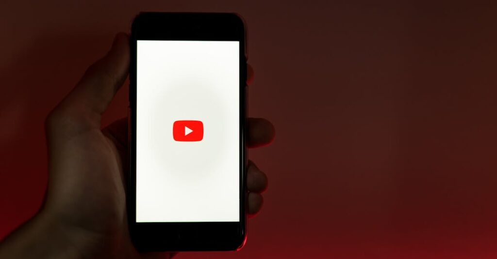pexels-photo-3227986-3227986 A hand holding a smartphone displaying the YouTube app against a red background.
